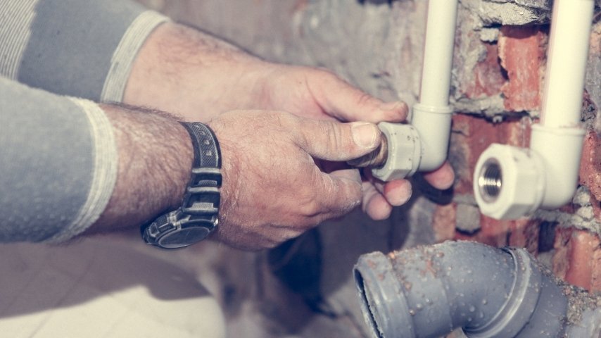 Copper and plastic first fix pipework set out in a stripped bathroom before tiling